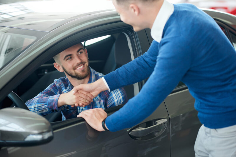 smiling customer shakes hands with salesperson