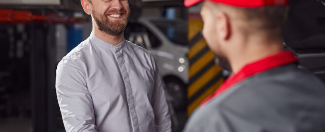 happy customer and mechanic in relaxed branded uniform