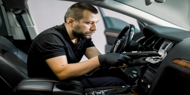 man detailing inside of car