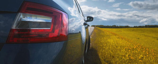 car parked beside a field in spring